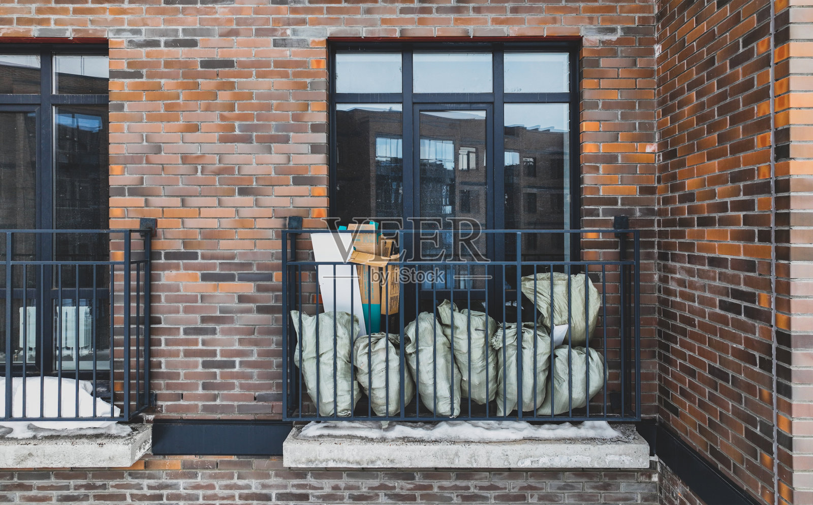 小阳台上的袋子和建筑碎片的特写。砖房照片摄影图片