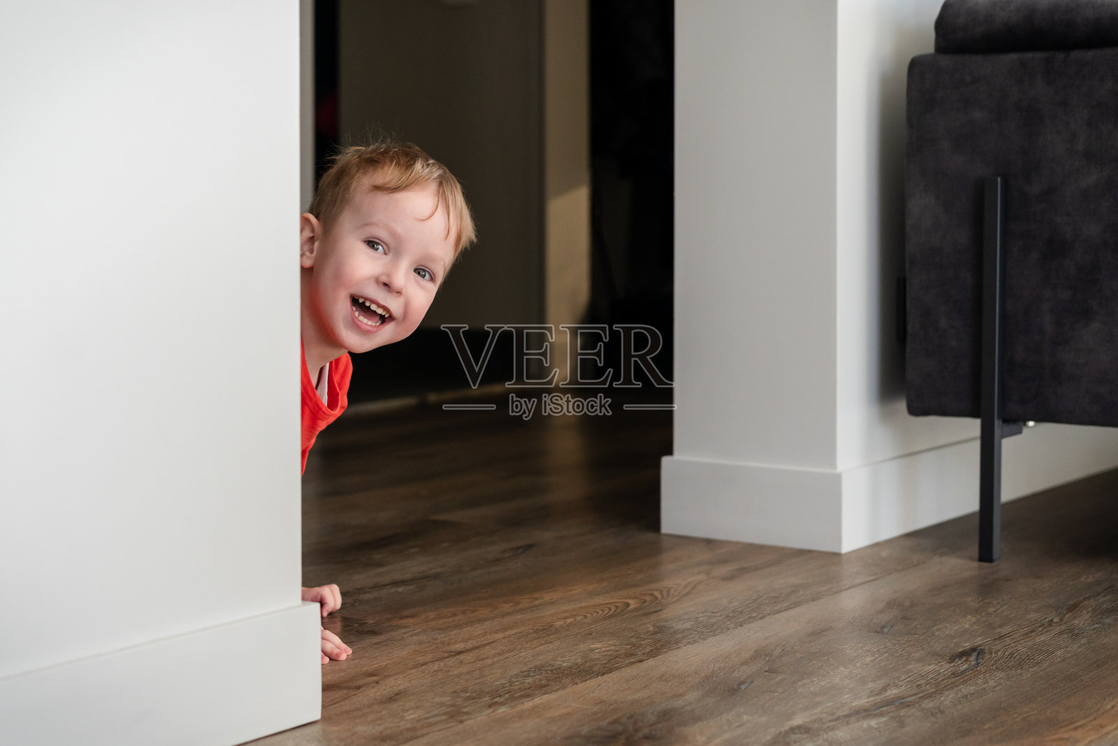 孩子，蹒跚学步的孩子，小男孩在家里玩捉迷藏。家里的欢乐，温暖舒适的地板。为孩子们提供有创意的室内活动。照片摄影图片