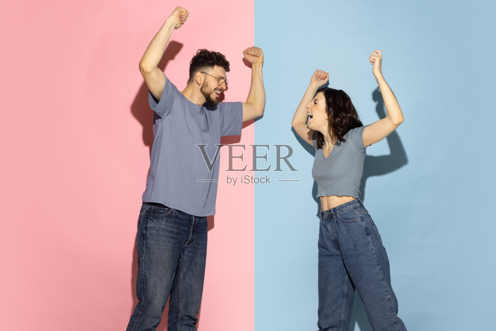 年轻感性的男人和女孩的肖像孤立在蓝色和粉红色流行的颜色背景。人类情感的概念照片摄影图片