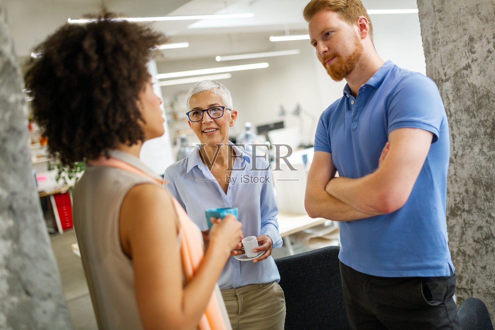 一群快乐的多民族商务人士，在工作场所的办公室里愉快地聊天照片摄影图片