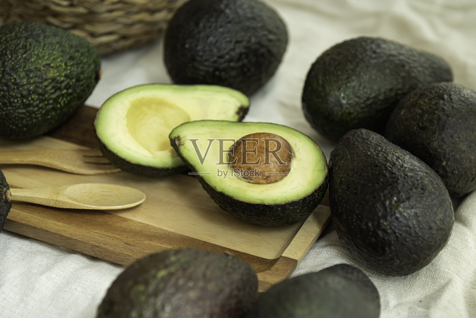牛油果放在木盘上，再铺上白布。照片摄影图片