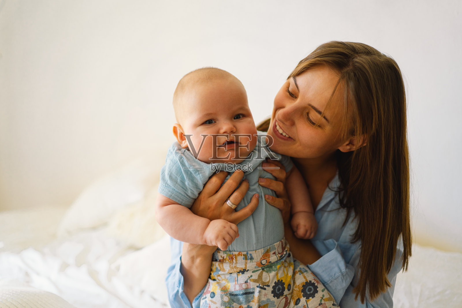 年轻母亲与小男婴玩耍，哺乳期母亲的温馨日常照片摄影图片