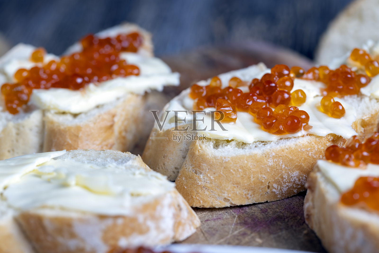 红鲑鱼或鳟鱼鱼子酱配白法棍和黄油照片摄影图片