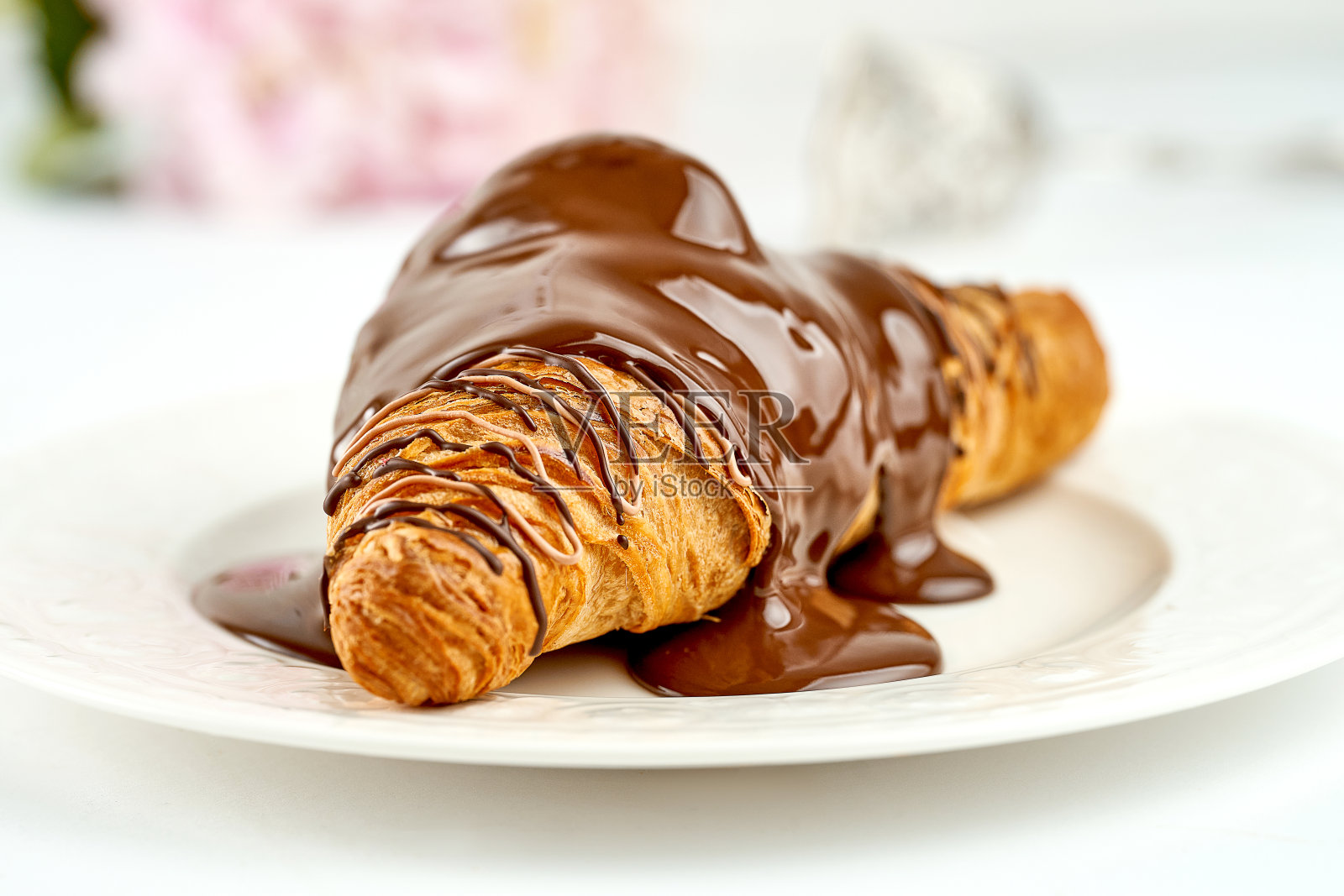 牛角面包和巧克力放在盘子里。选择性的焦点。开孔照片摄影图片