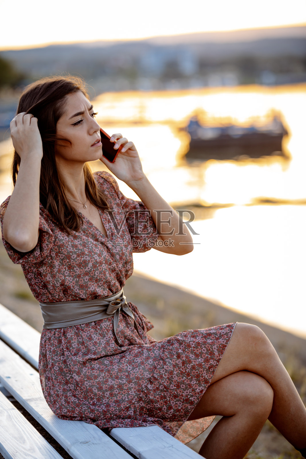 年轻女子在夏日夕阳下使用手机照片摄影图片