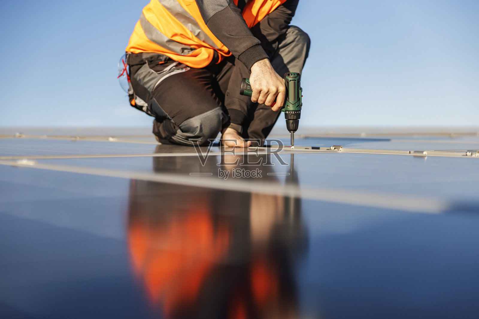 裁剪图片的工人安装太阳能电池板在屋顶上。照片摄影图片