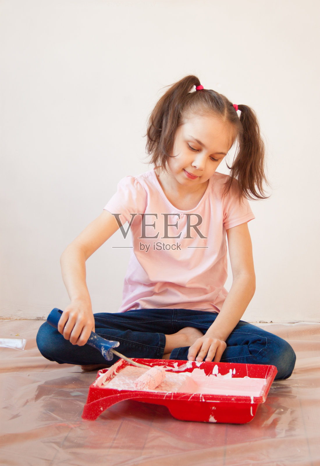 一个手里拿着颜料滚筒的女孩照片摄影图片