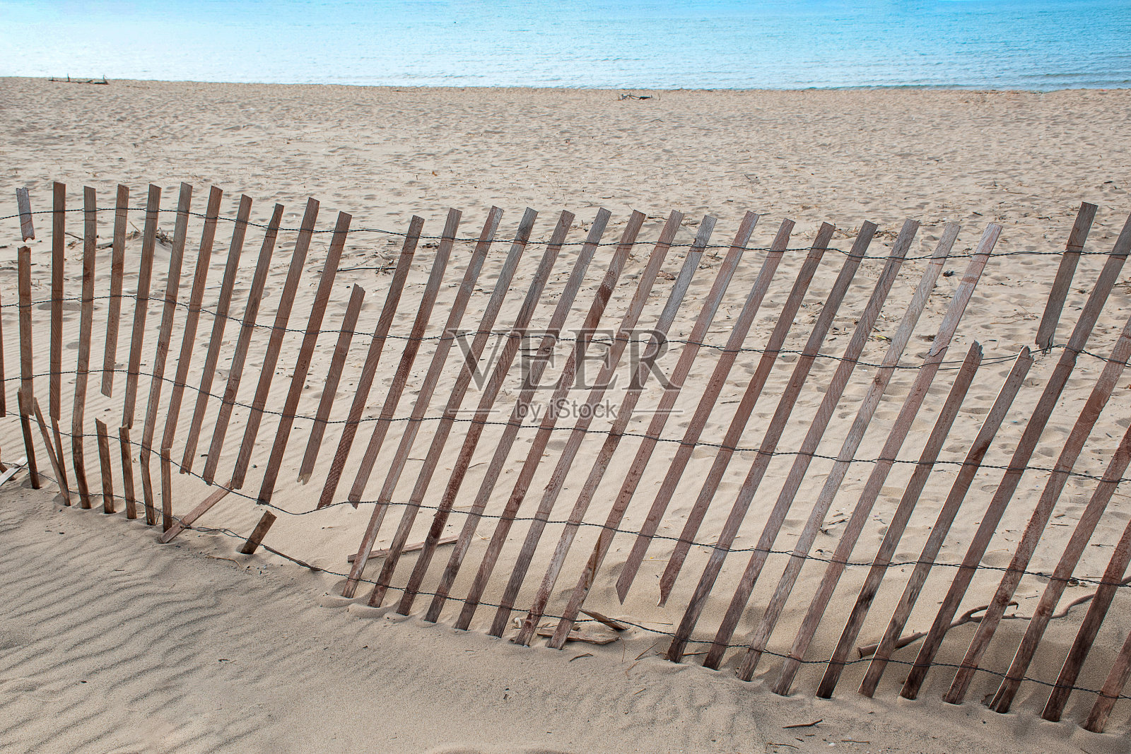 海滩上破碎的雪栅栏照片摄影图片