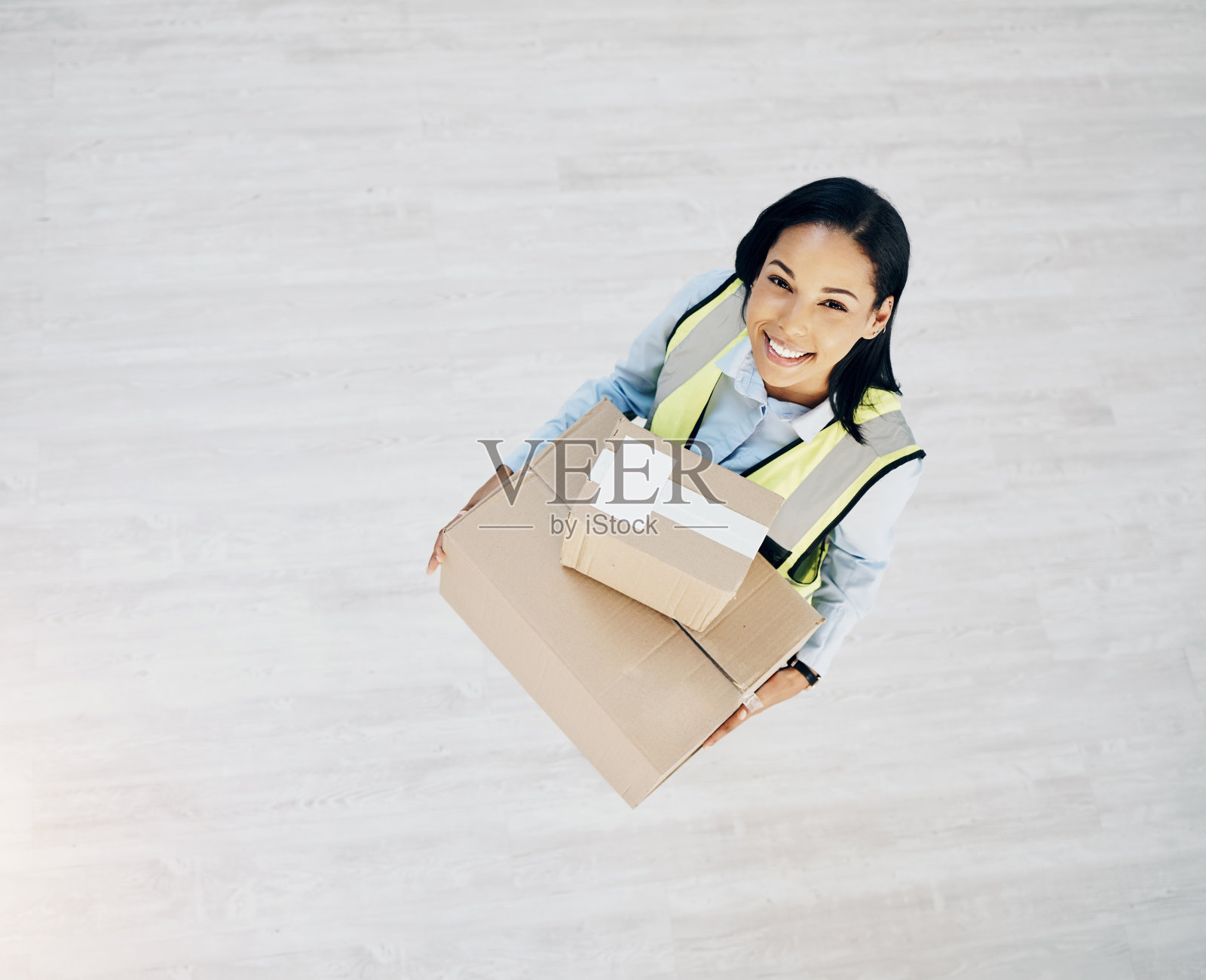 一个年轻女人拿着要送的箱子的高角度镜头照片摄影图片