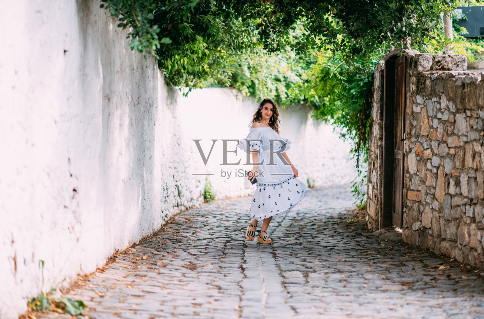 穿着白裙子的女游客在街上探索照片摄影图片