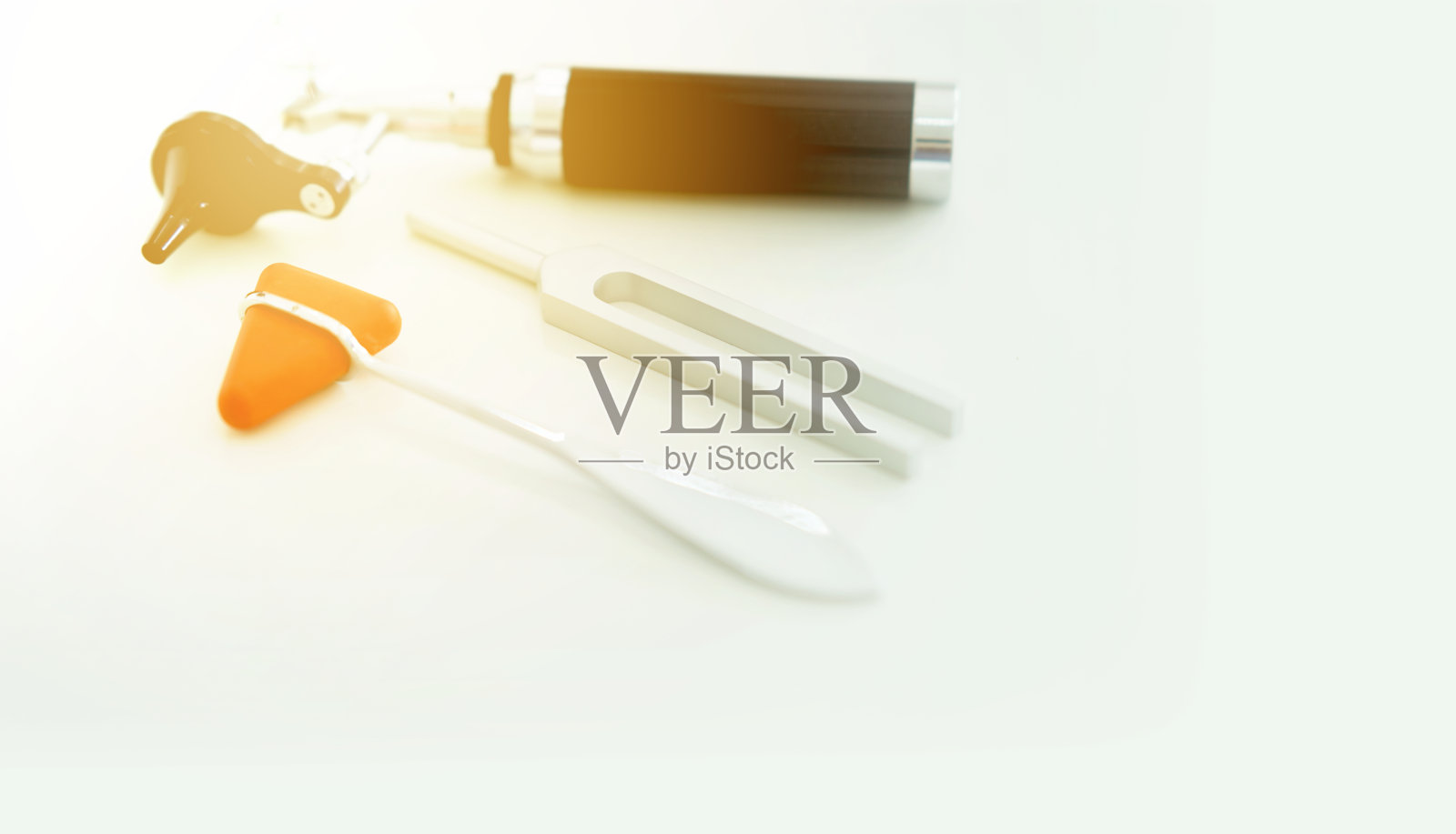 音叉和模糊耳镜和锤击在白色地板上，与太阳的顶视图照片摄影图片