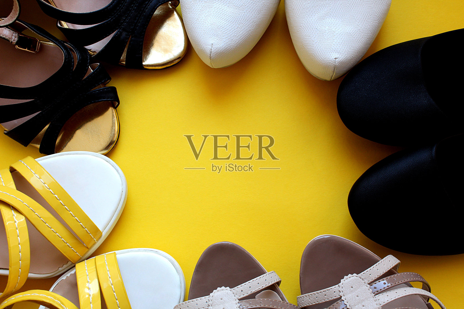 黄色的背景上立着一堆鞋子。照片摄影图片