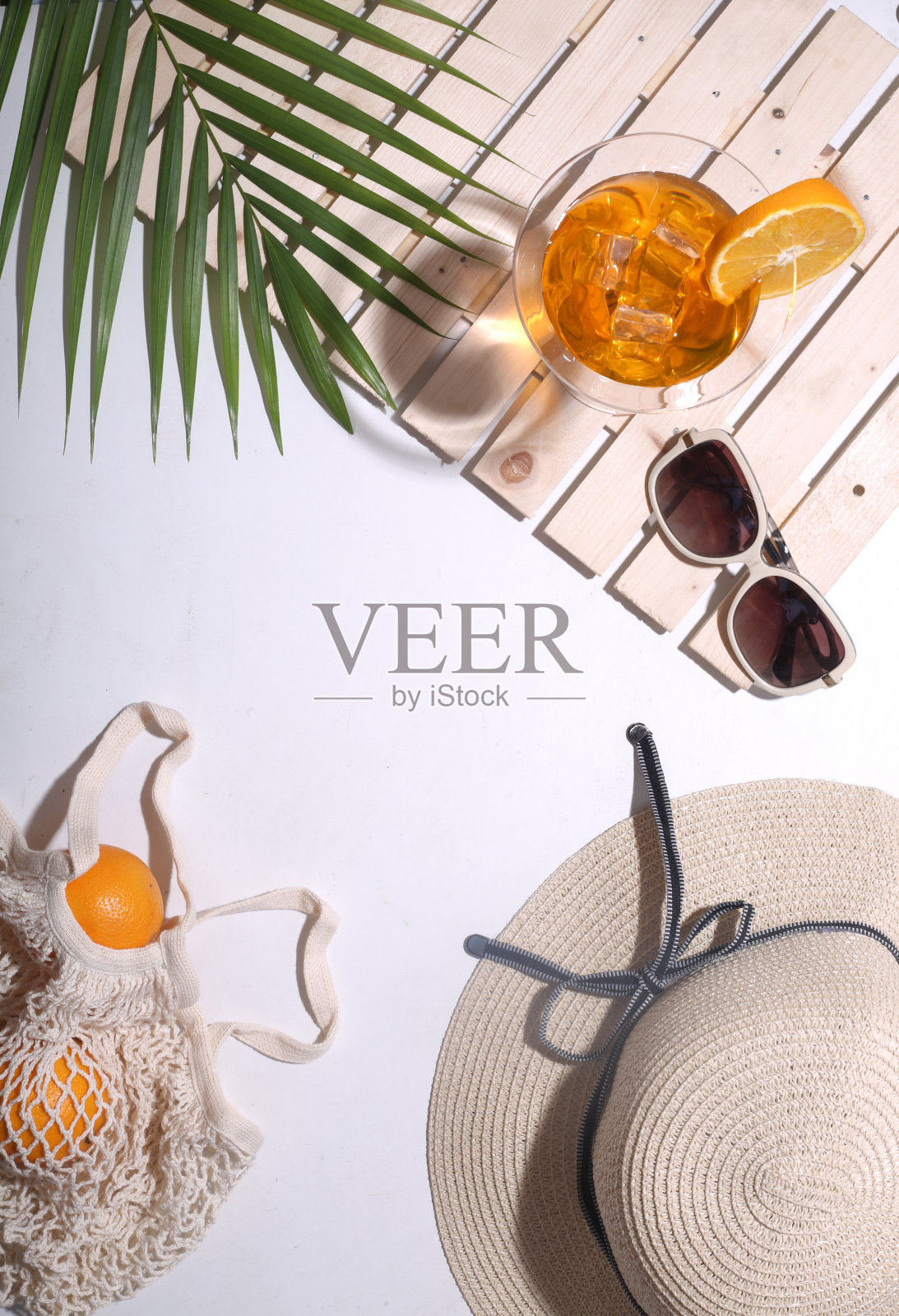 用帽子、橘子、棕榈叶、果汁等夏季道具平铺维生素c护肤产品。俯视图照片摄影图片