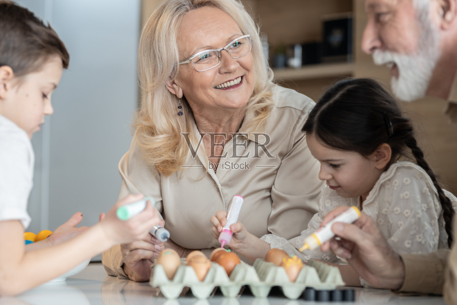 奶奶和孙子孙女们在画鸡蛋照片摄影图片