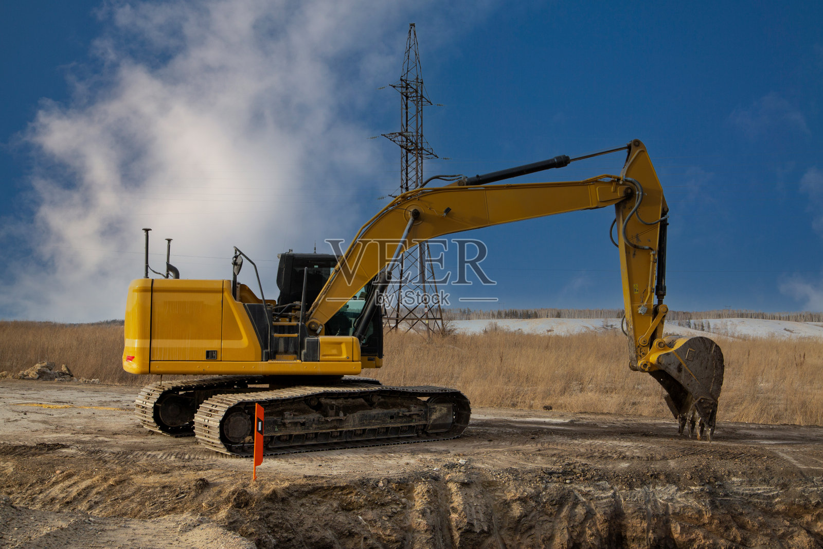 一种正在使用的带有附件的挖掘机，用于建造道路交叉路口。照片摄影图片