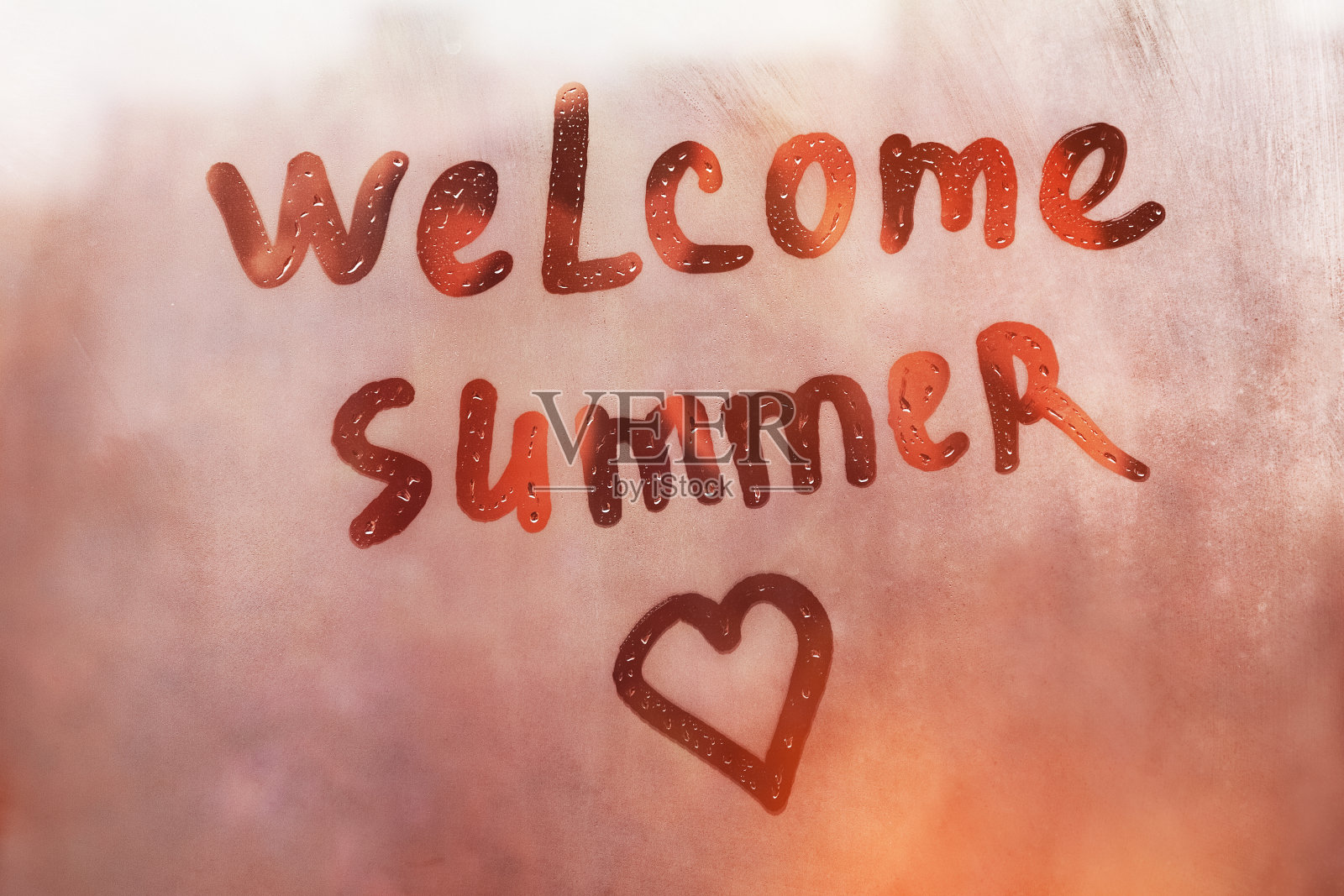 欢迎夏天的手写文字和心的形状湿漉漉的橙色窗户在城市的日落照片摄影图片