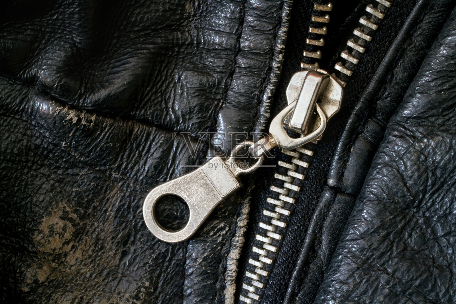 破旧皮夹克上的拉链。照片摄影图片