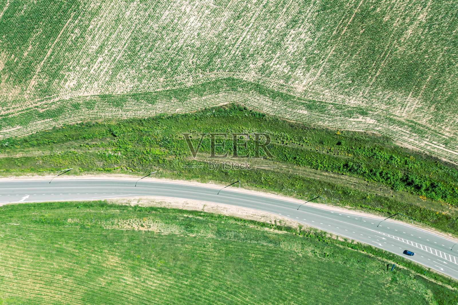 农田之间的乡间公路。农村夏天的风景。鸟瞰图。照片摄影图片