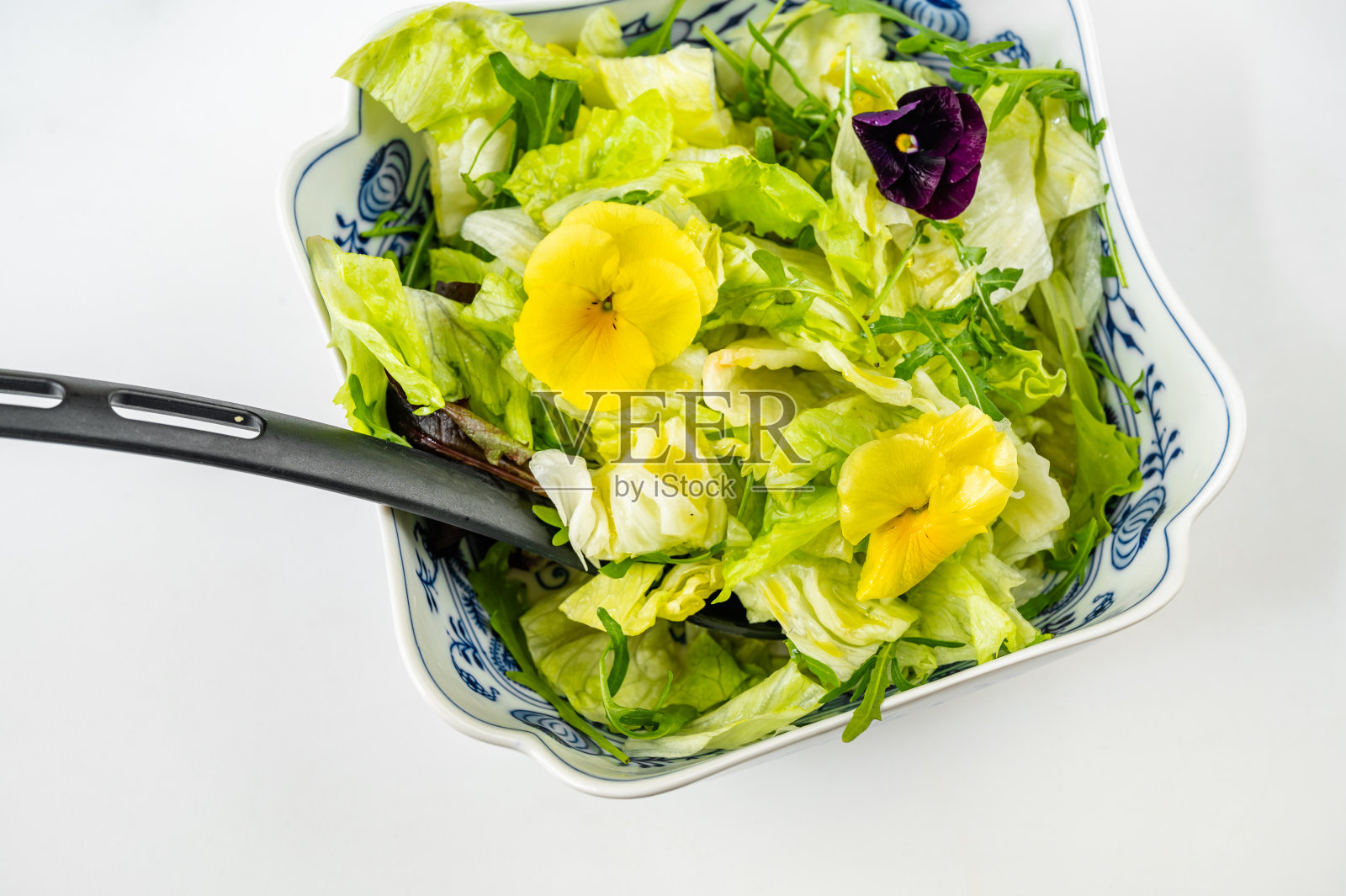 新鲜的绿色沙拉(生菜，莴苣，红甜菜)与三色堇花碗，特写。照片摄影图片