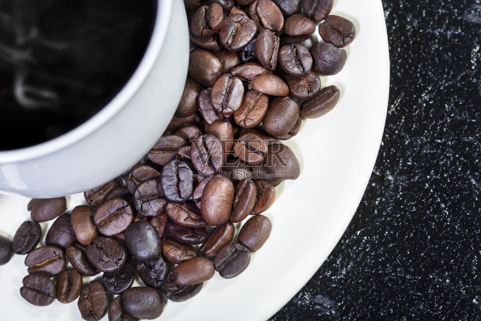 烘焙咖啡颗粒在黑色纹理背景照片摄影图片