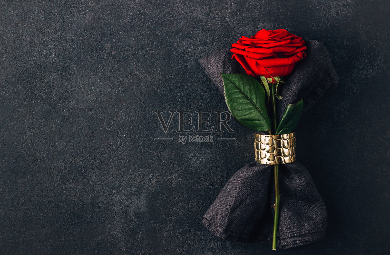 情人节的餐桌上摆满了黑色的餐巾和玫瑰。平躺照片摄影图片