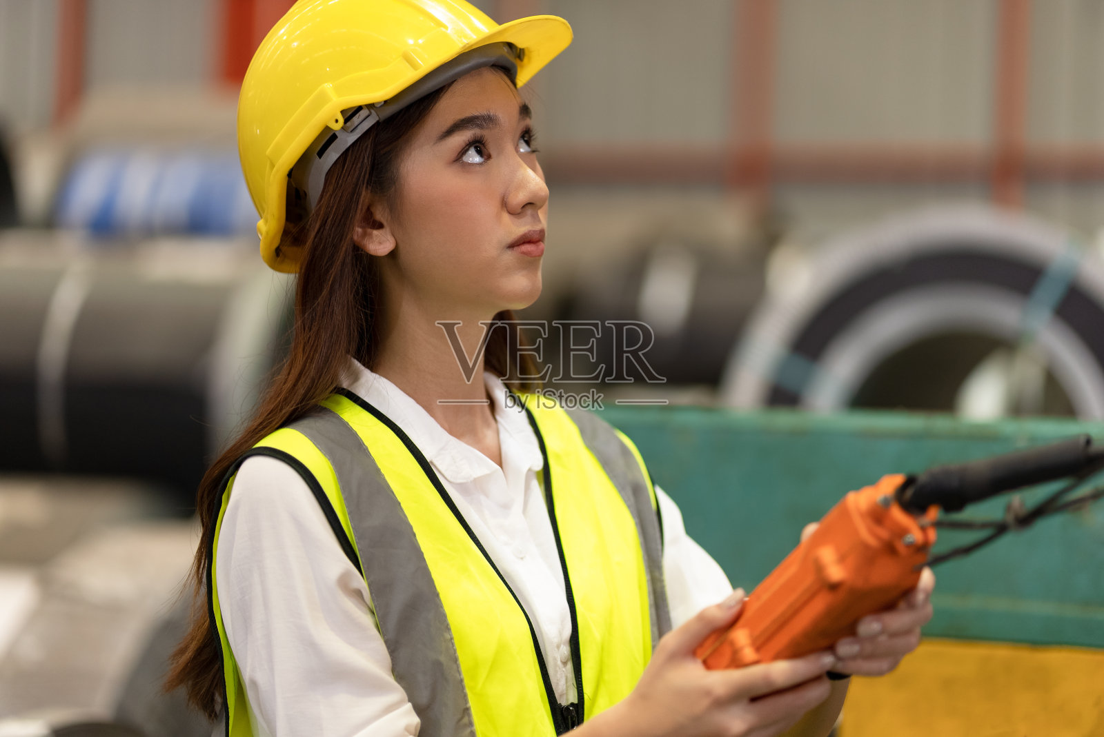 女工程师或领班在工厂使用遥控设备工作照片摄影图片