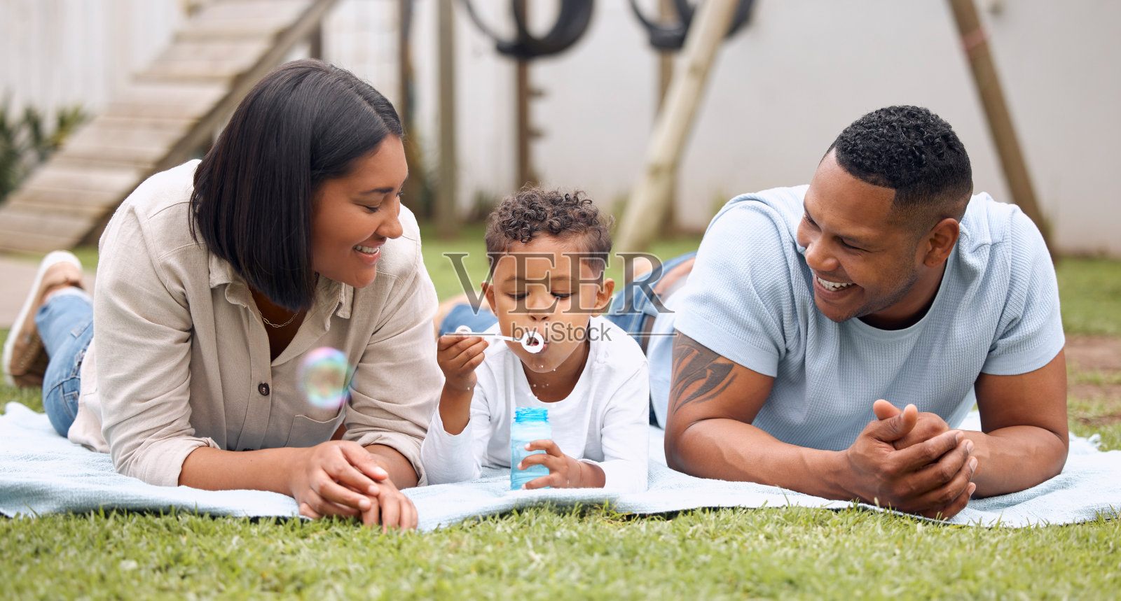 这张照片拍摄的是一家人玩得很开心，而他们的儿子在外面吹泡泡照片摄影图片
