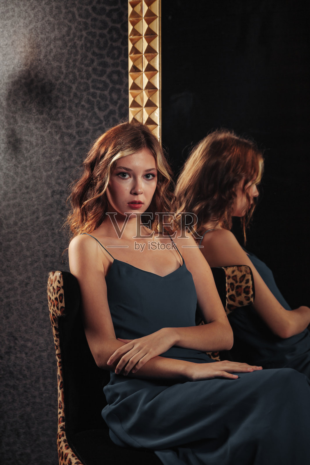 肖像的漂亮可爱的少女在一个优雅的裙子在镜子照片摄影图片