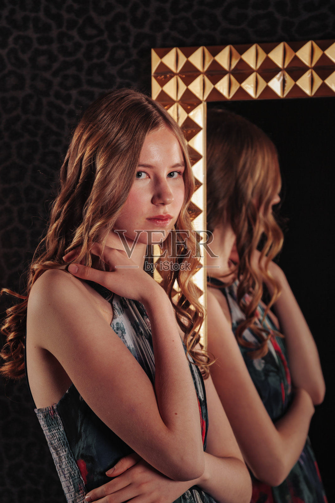 肖像的漂亮可爱的少女在一个优雅的裙子在镜子照片摄影图片