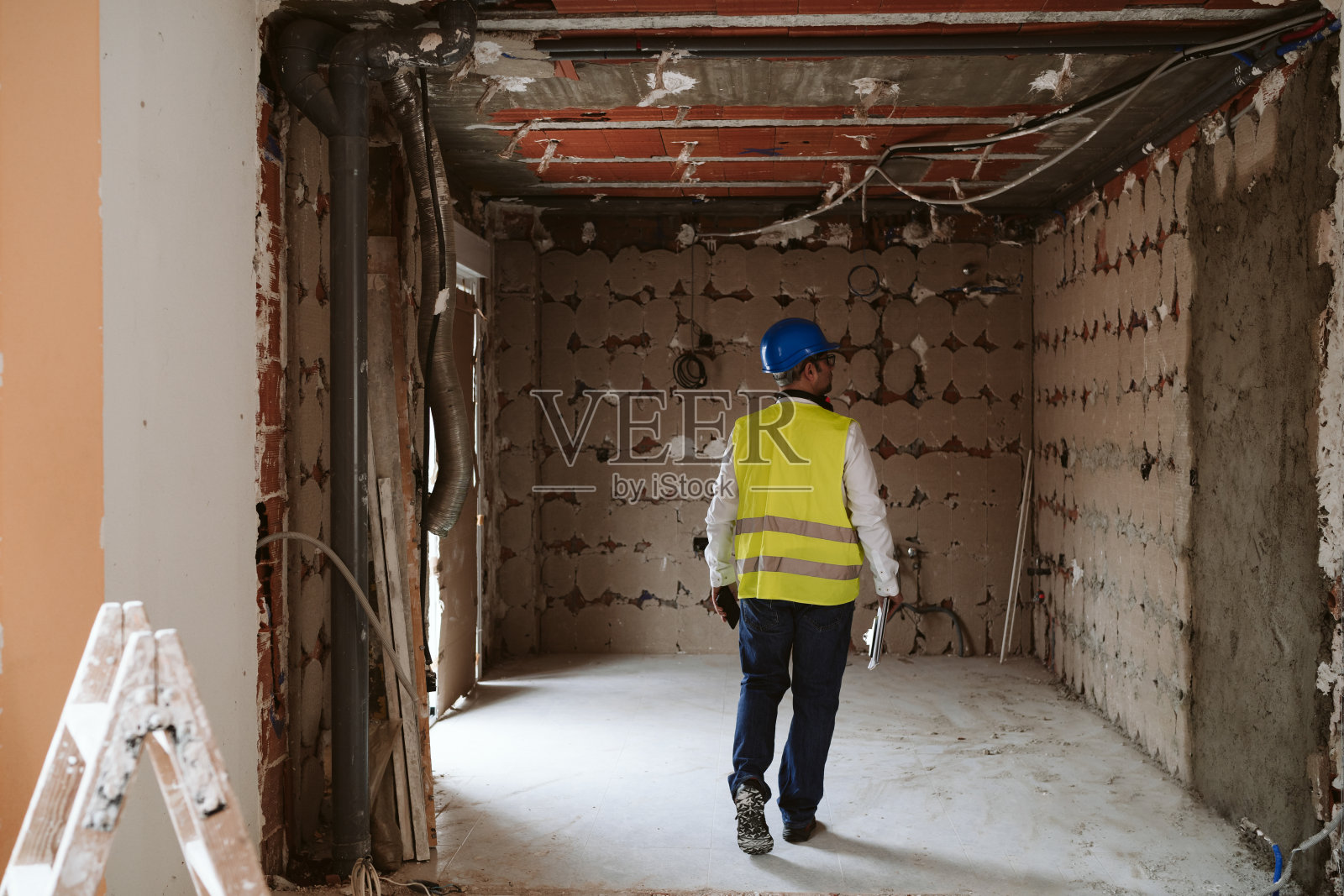工头或不知名的建筑师在建筑工地设计图纸。家居装饰照片摄影图片