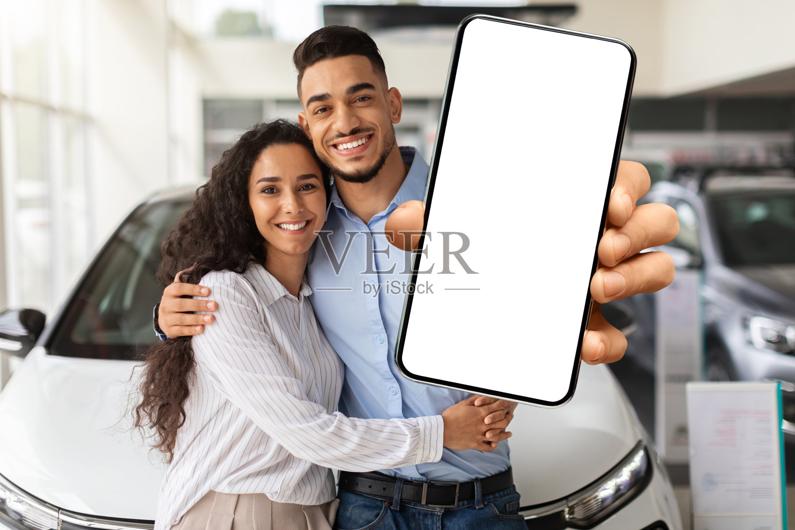 有爱心的穆斯林家庭展示了黑屏的智能手机，购买了汽车照片摄影图片