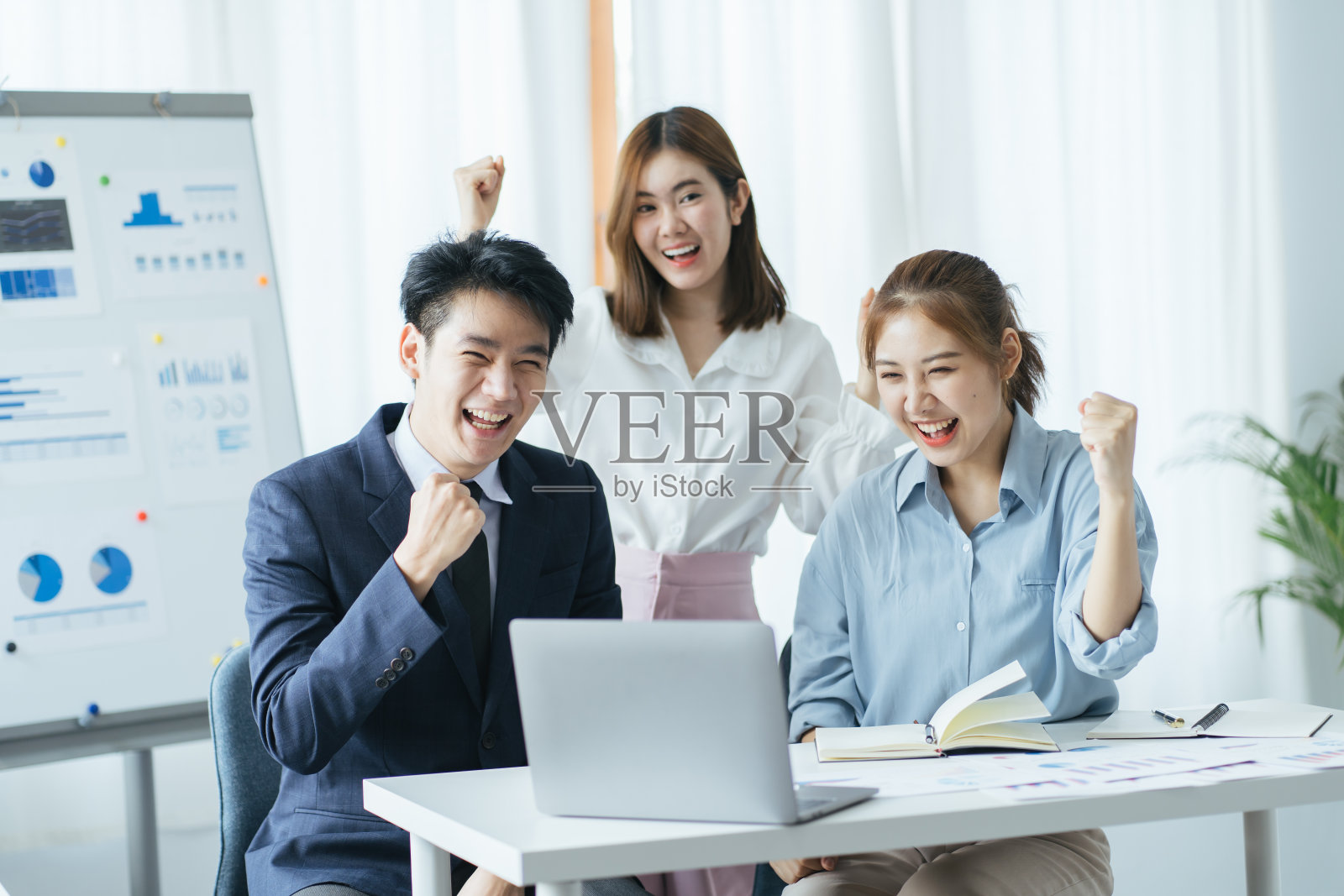 身着正装的亚洲年轻商务人士，以快乐的笑脸和城市景观为背景，展现项目成功和圆满的成功象征意义照片摄影图片