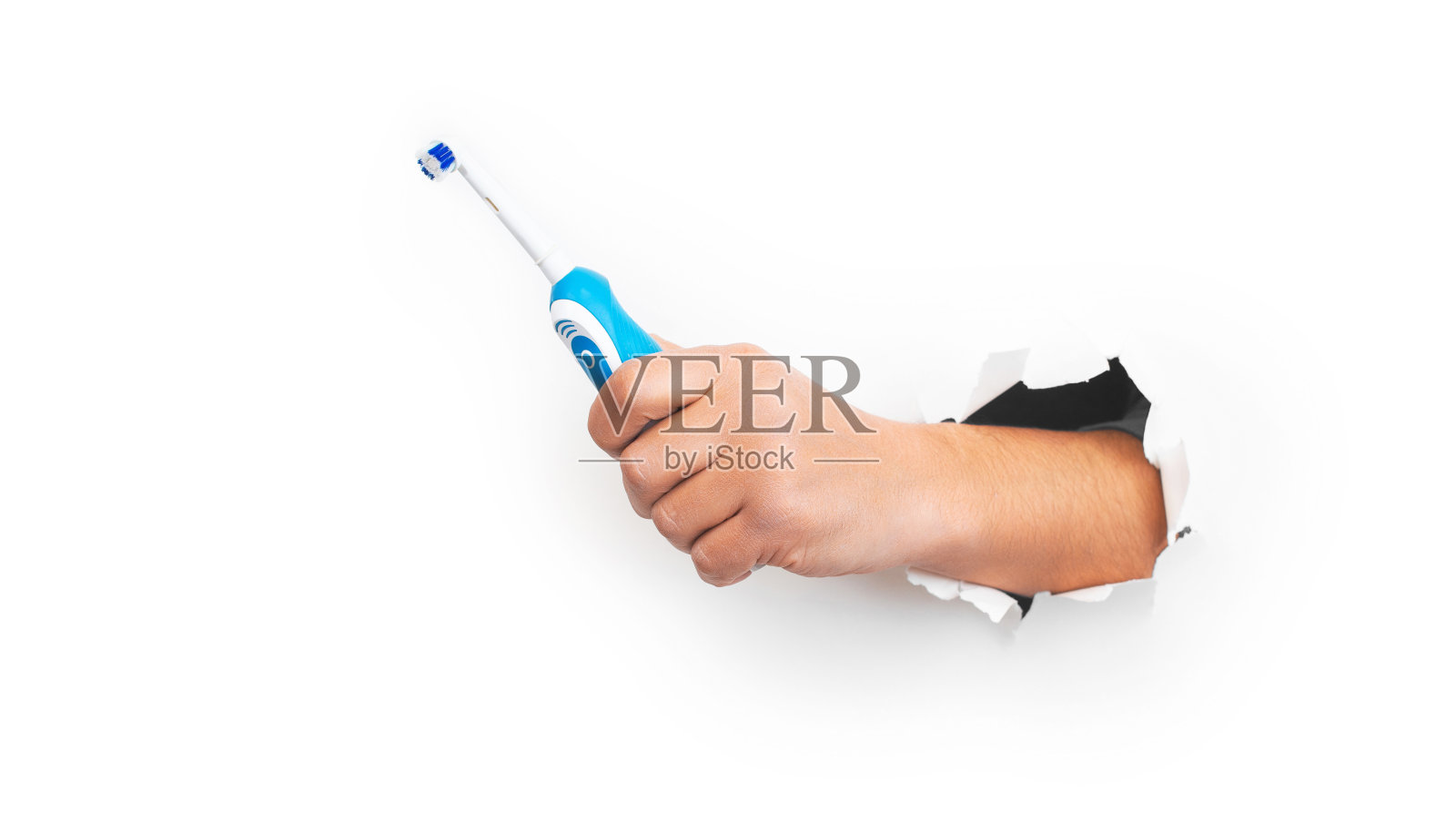 男性手握现代电动牙刷在白色背景。横幅,复制空间。控制口腔卫生工具，广告空间。照片摄影图片