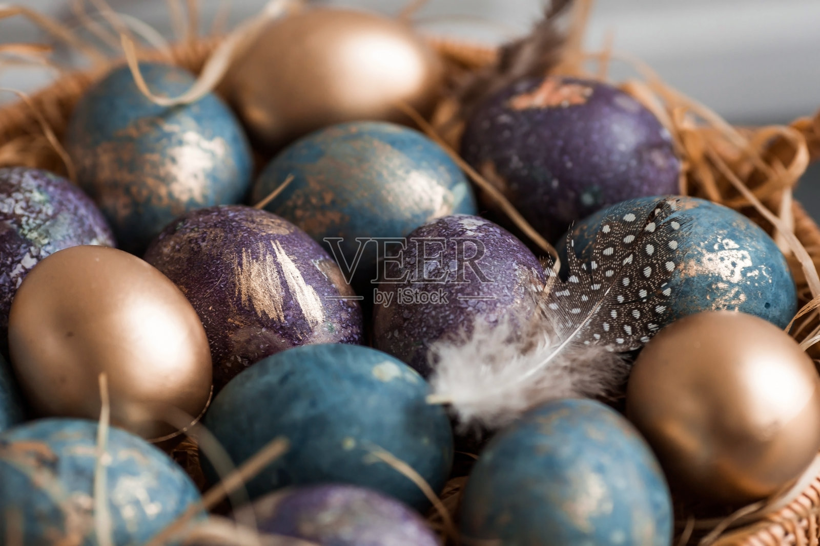 紫色、蓝色和金色的鸡蛋放在黑色背景的篮子里。2022年的紫色趋势是非常接近的。天然染料karkade茶。前视图。复活节卡片上有副本的文字。照片摄影图片