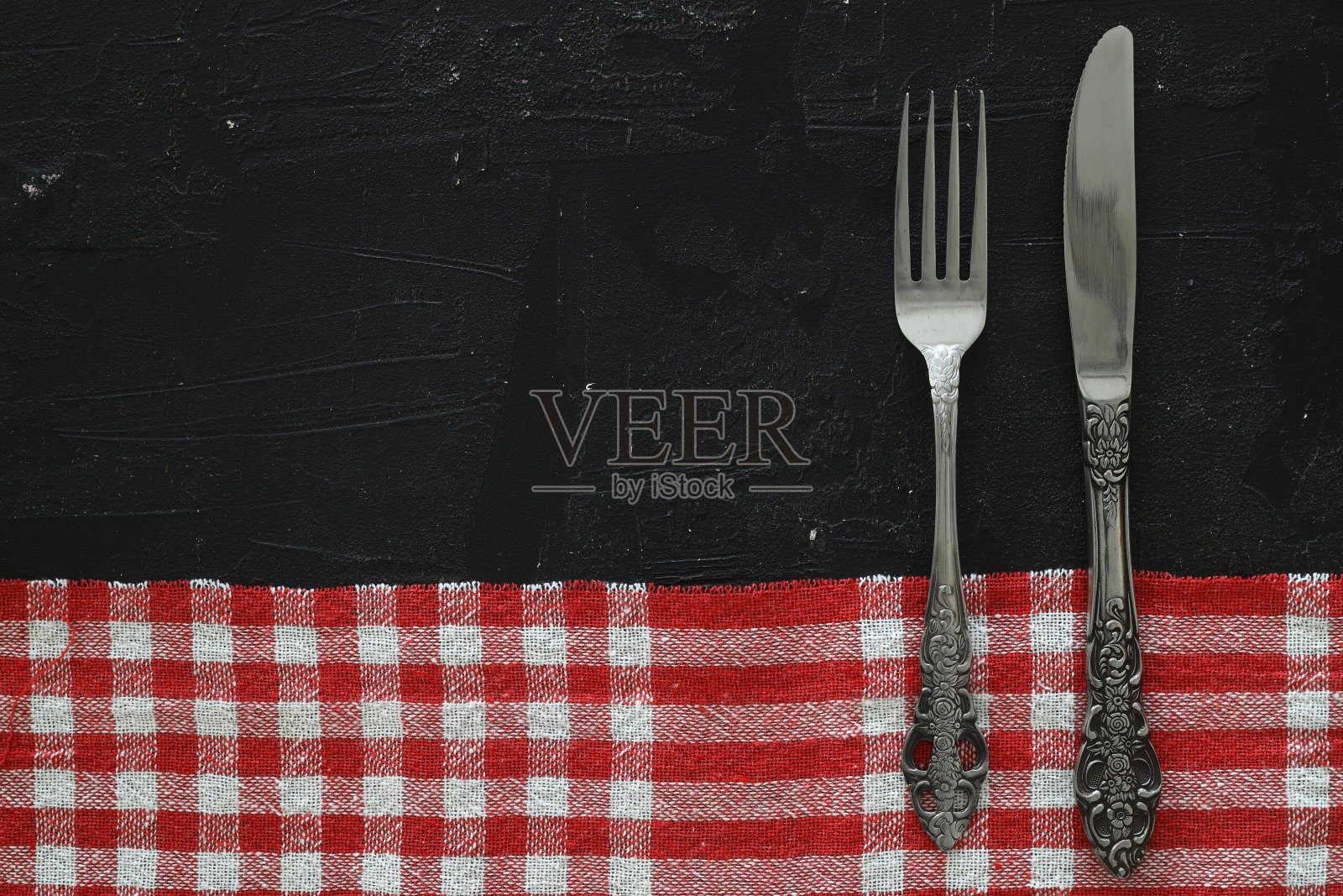 头顶上的银餐具在黑色的桌子上与复制空间。照片摄影图片