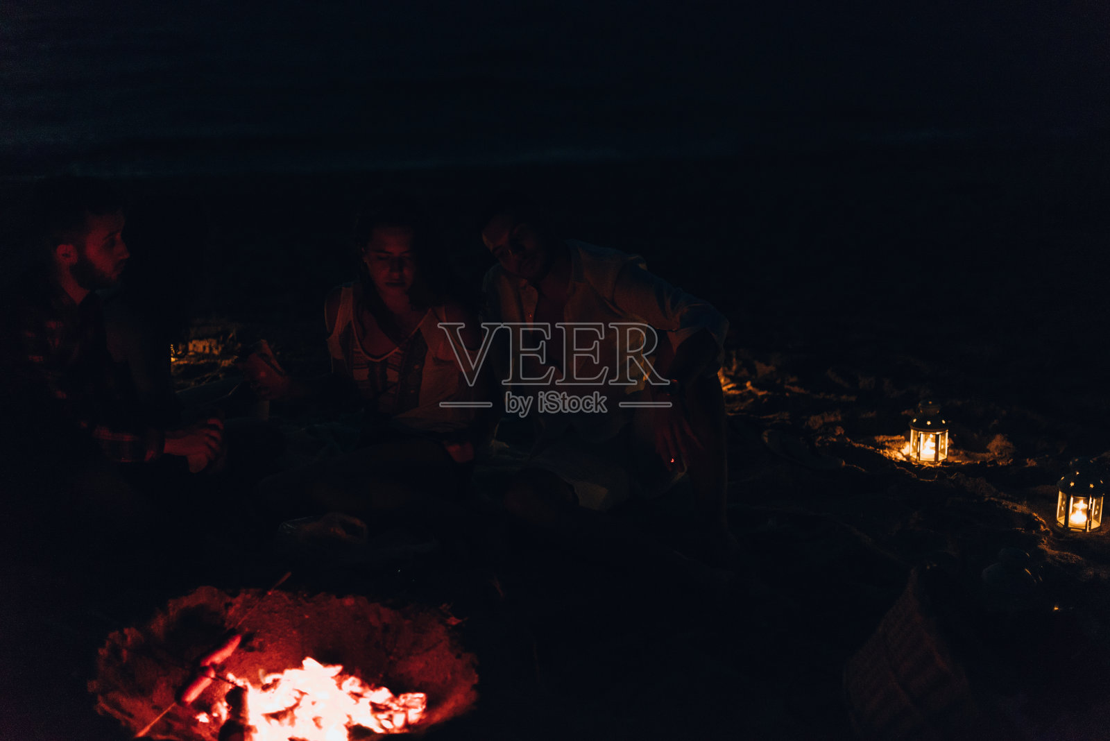 野餐时在燃烧的余烬上烤香肠照片摄影图片