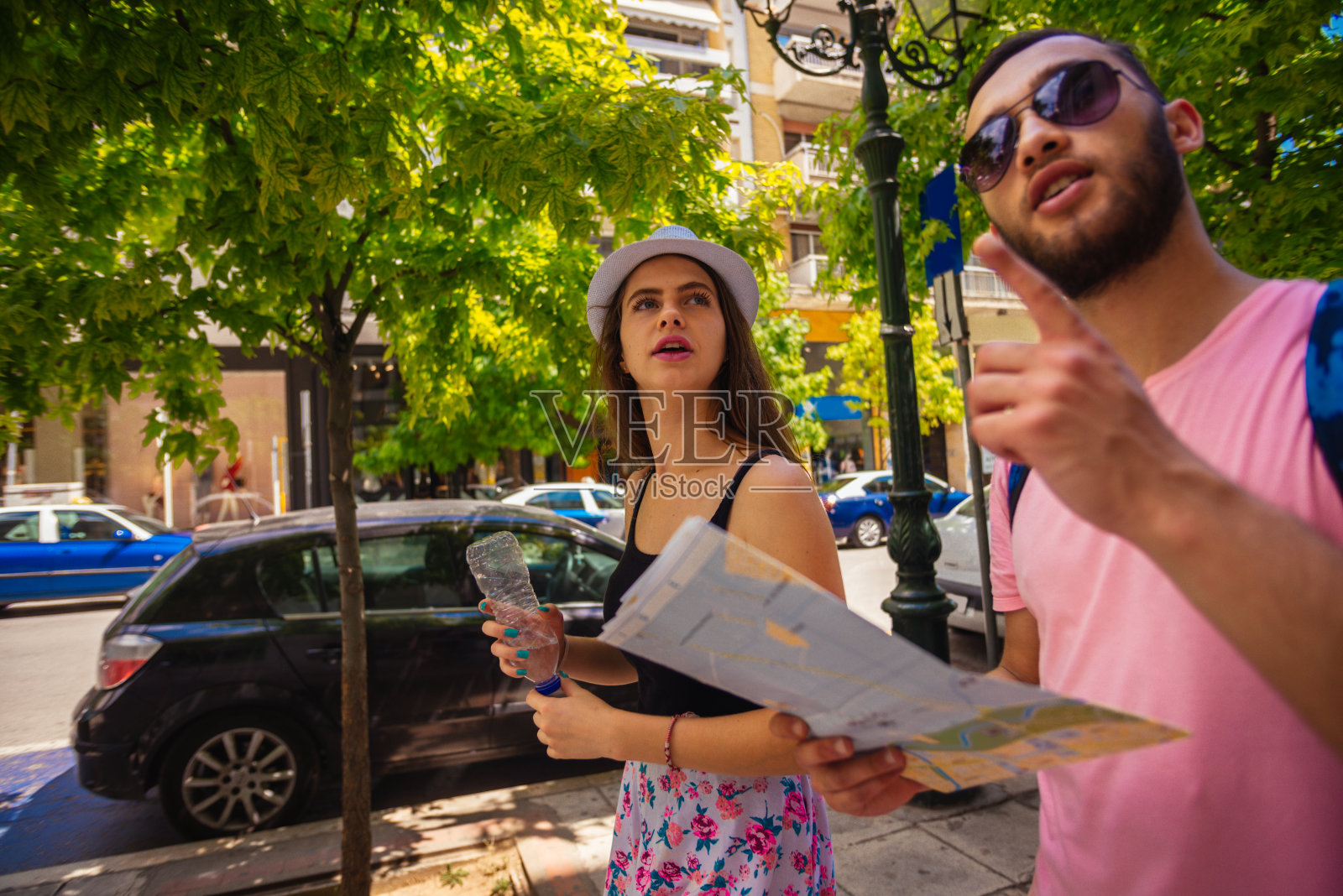 一对年轻夫妇一边看旅游地图，一边探索这座城市照片摄影图片