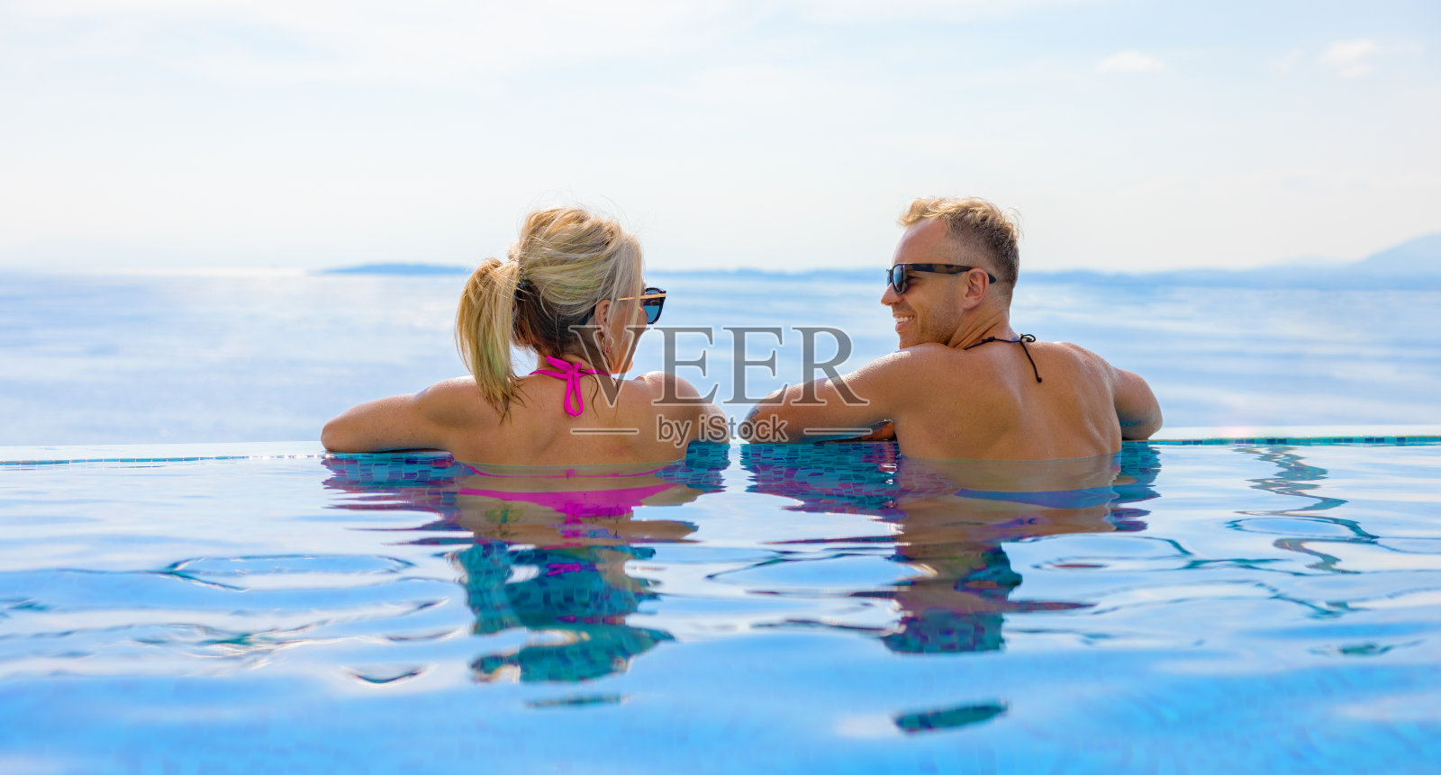 情侣们在美丽的海景泳池放松照片摄影图片