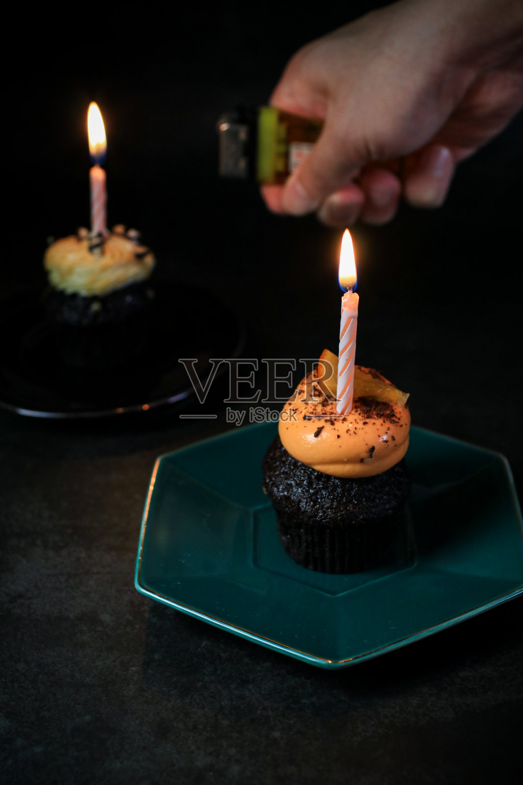 巧克力生日纸杯蛋糕，黑色背景上只有一支蜡烛。照片摄影图片