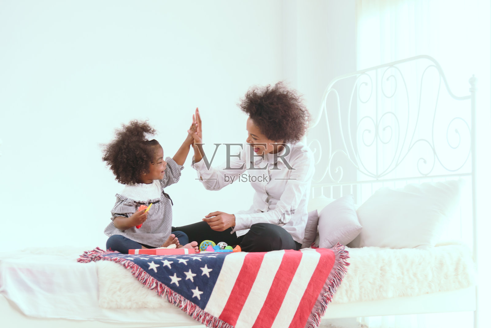 年轻的非洲母亲在家里抚养她的孩子，并充满爱意地和他们一起玩耍。照片摄影图片