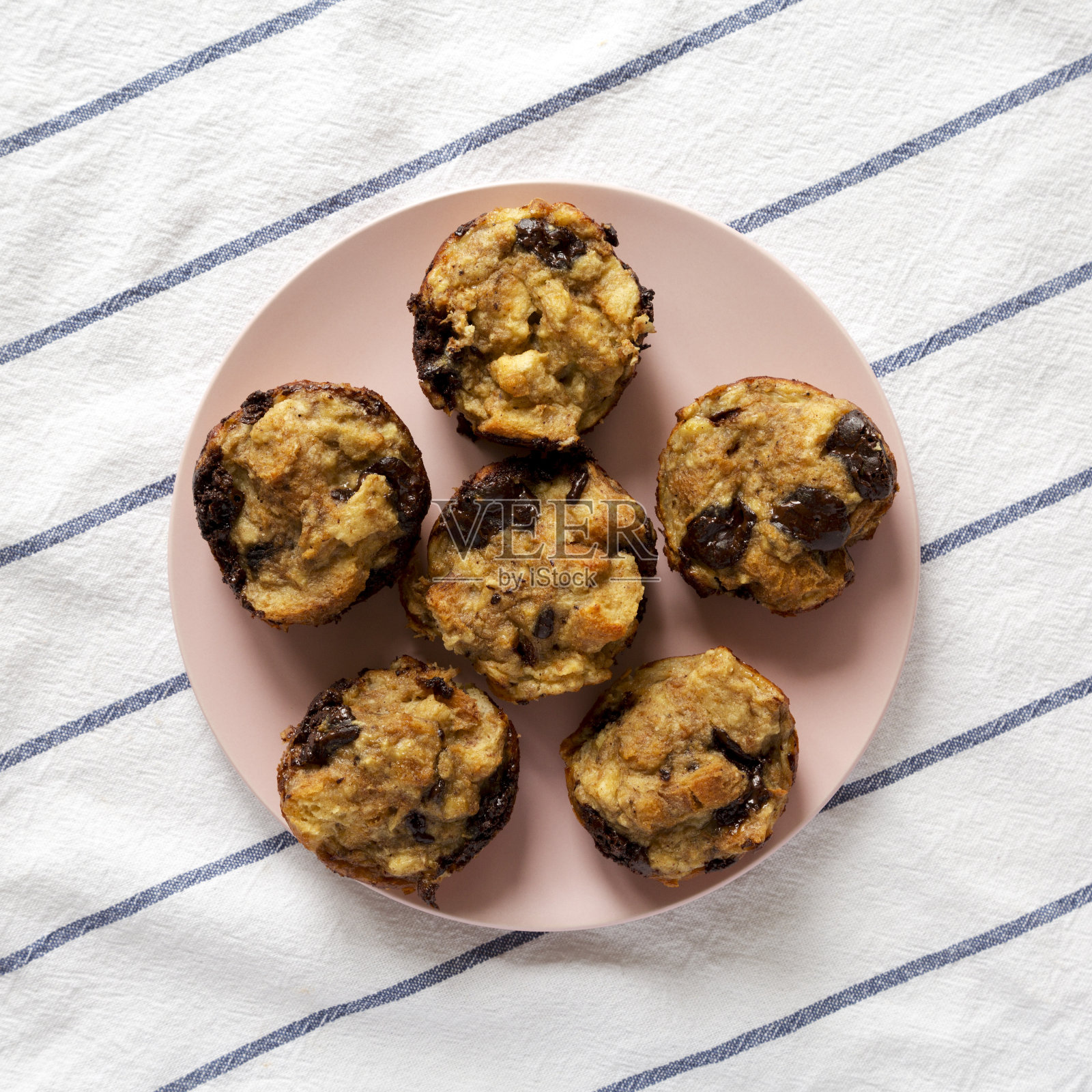 粉红色盘子上自制巧克力香蕉面包布丁，俯视图。平躺着，头顶上，从上面。照片摄影图片