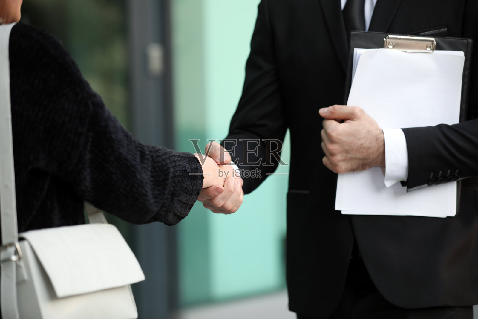 两个年轻人在握手，房地产经纪人，销售专员照片摄影图片