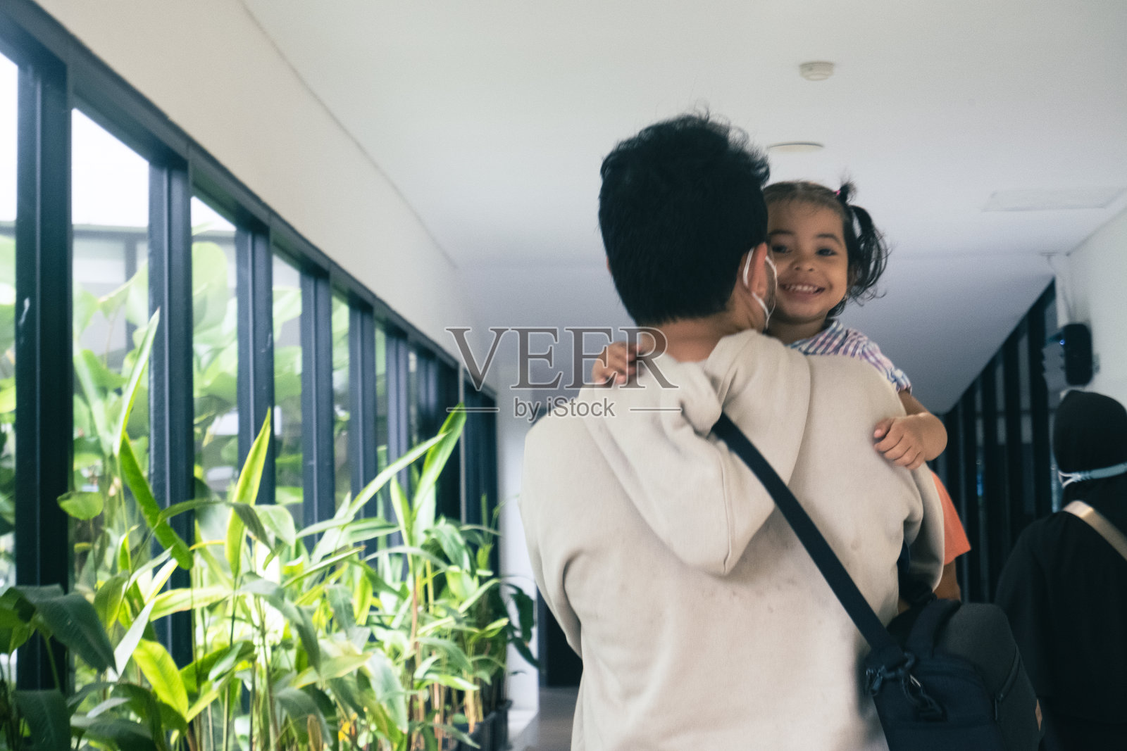 一位父亲抱着女儿走在超市的过道上照片摄影图片