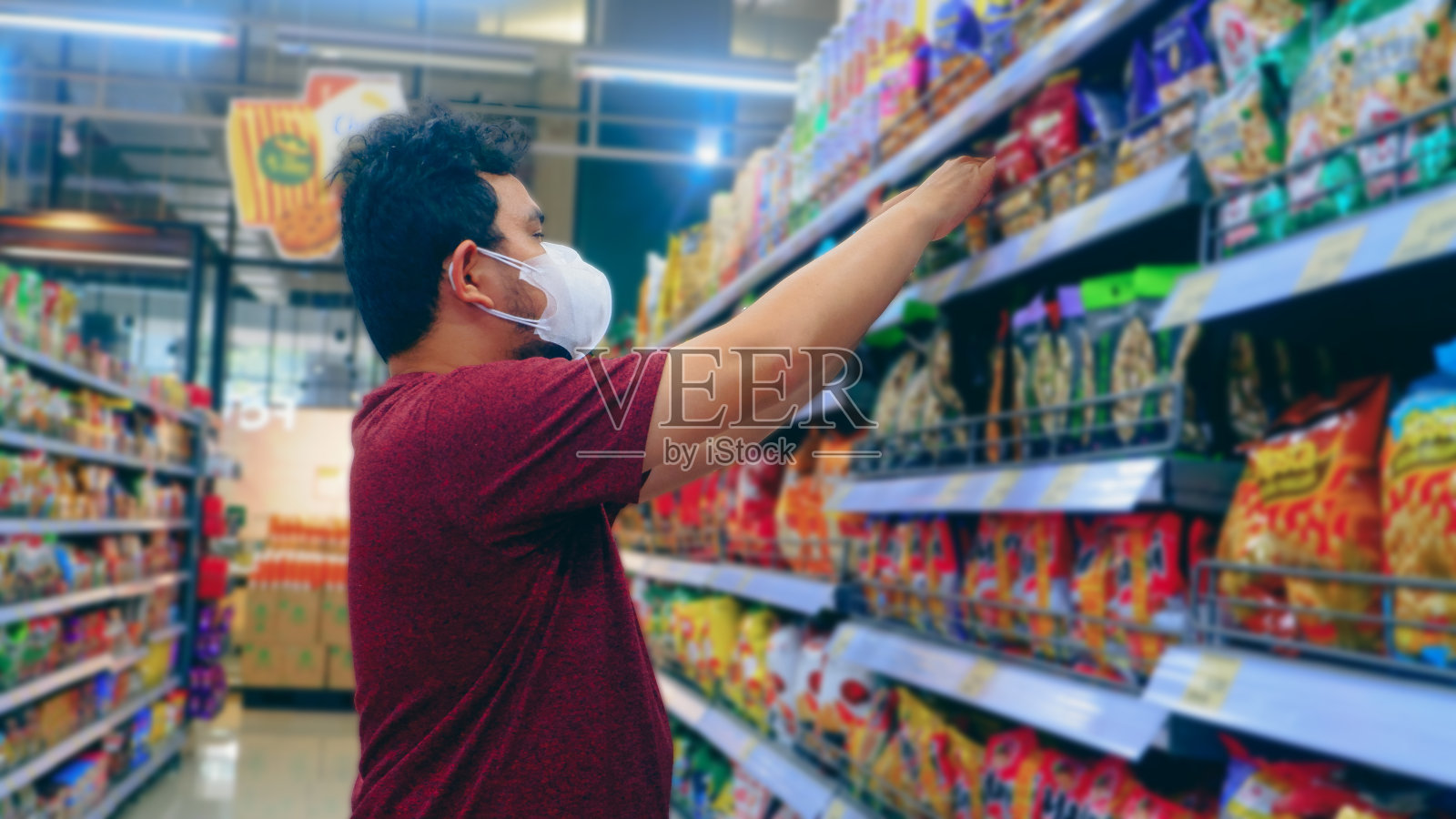 一名戴着口罩的男子正在便利店购物照片摄影图片