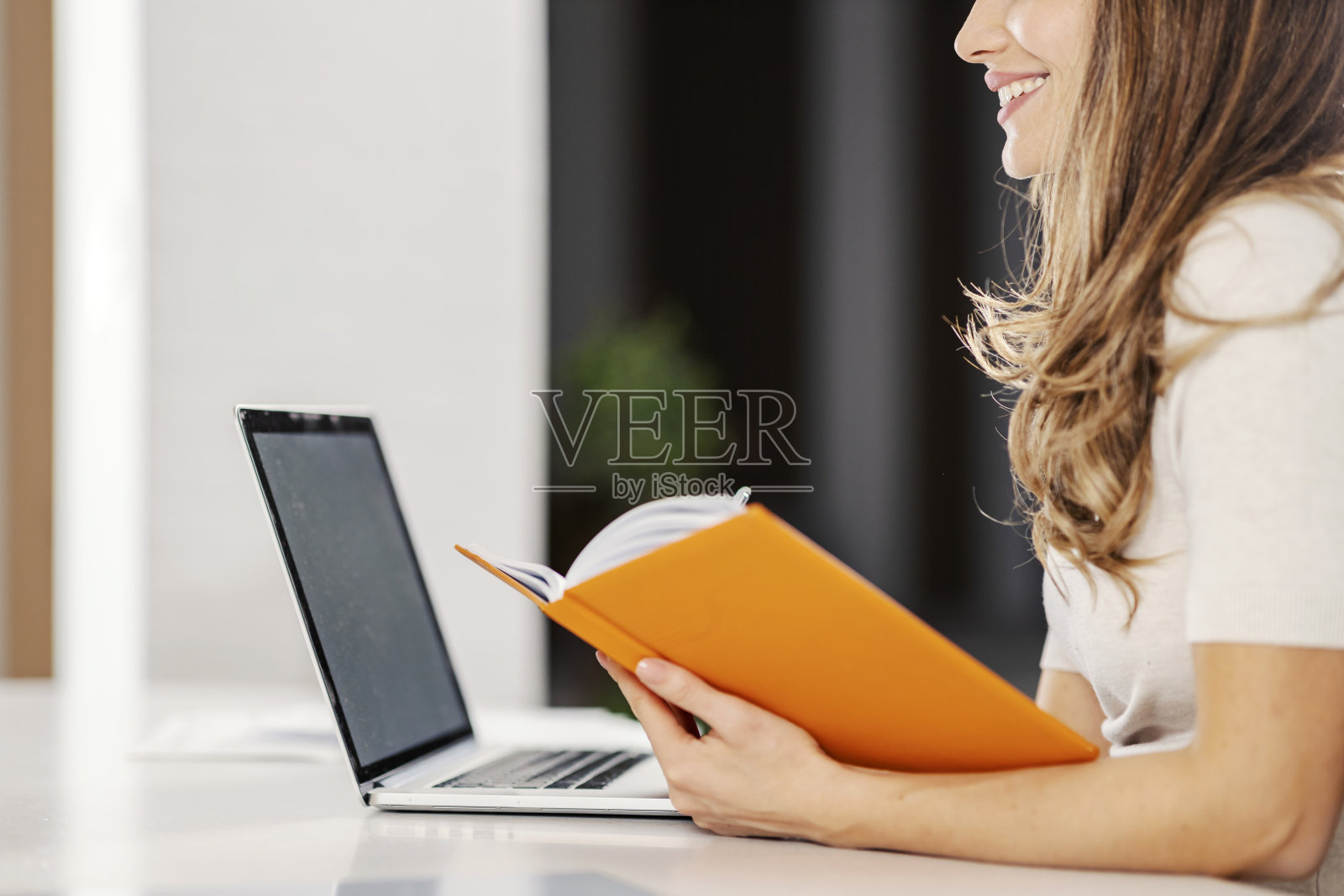 一个快乐的女人晚上在家听在线讲座。照片摄影图片