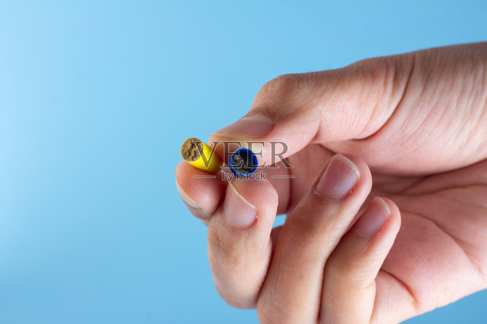 在蓝色的背景下，胶囊中的抗生素粉末被分离出来。照片摄影图片