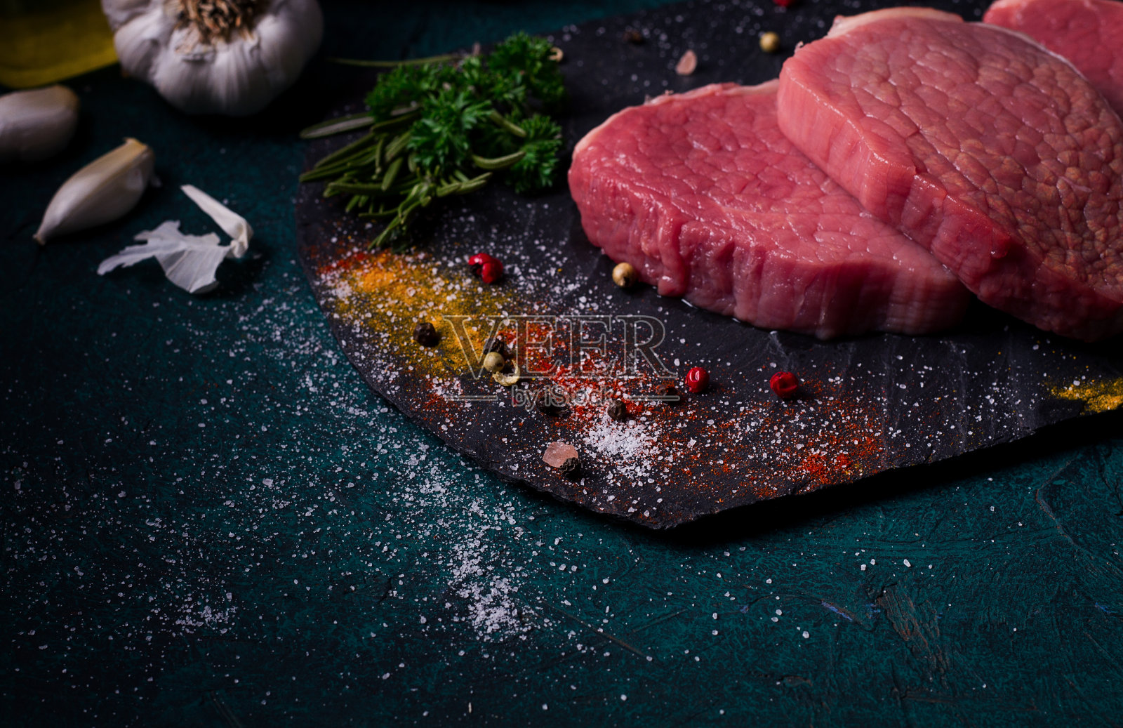 新鲜的生牛肉，大奖章，在黑色石板上，与香料，特写，水平，照片摄影图片