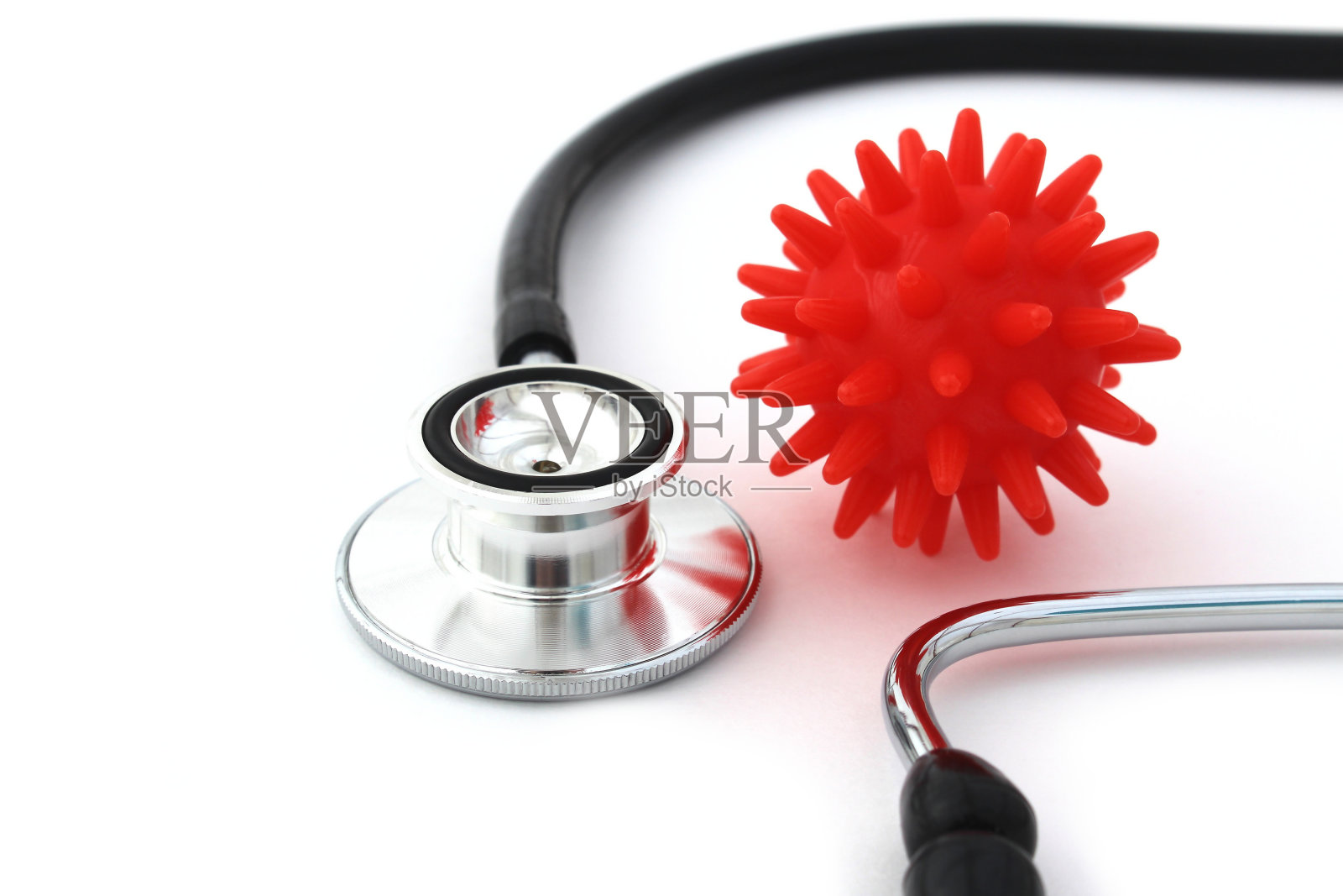白色背景上放着一个带有红色病毒模型的听诊器。照片摄影图片