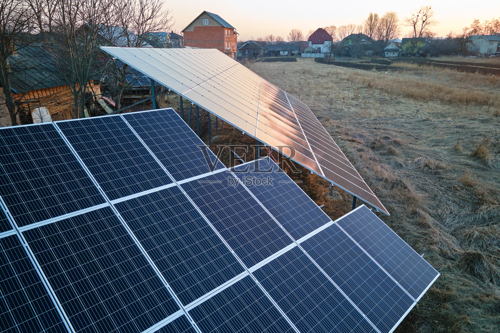 郊区农村后院地面安装太阳能光伏板，用于生产清洁的生态电能。自主住宅的概念照片摄影图片