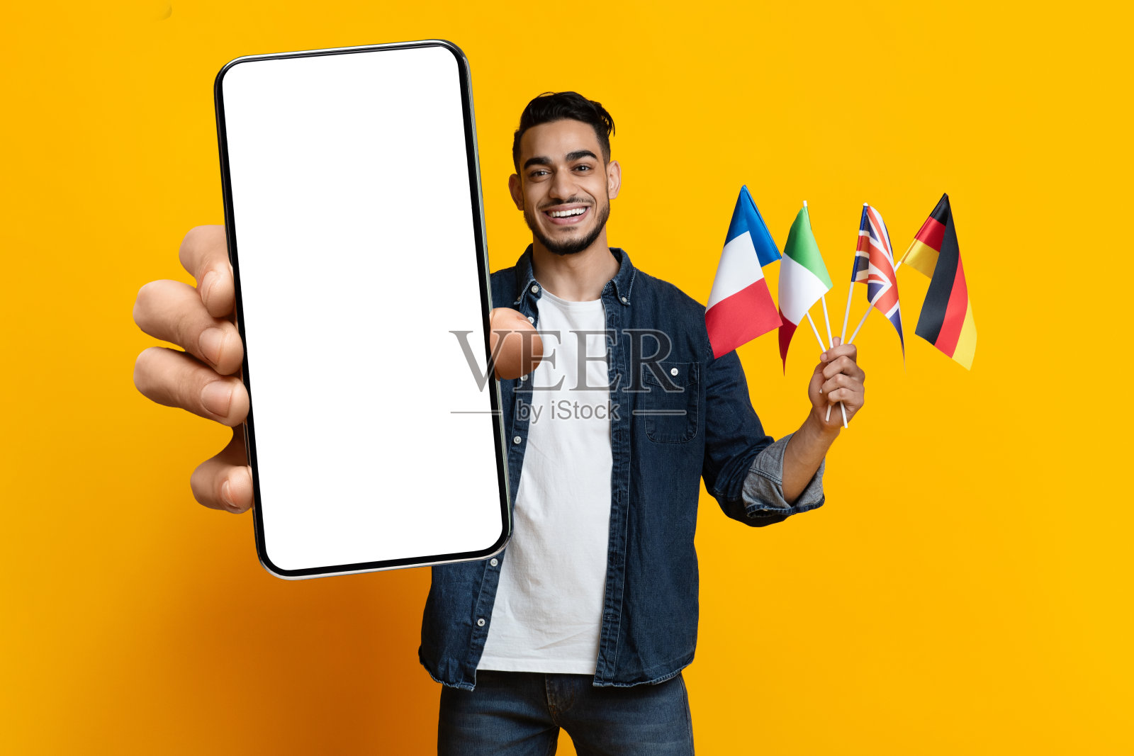 正面的中东学生展示国旗和智能手机，模型照片摄影图片
